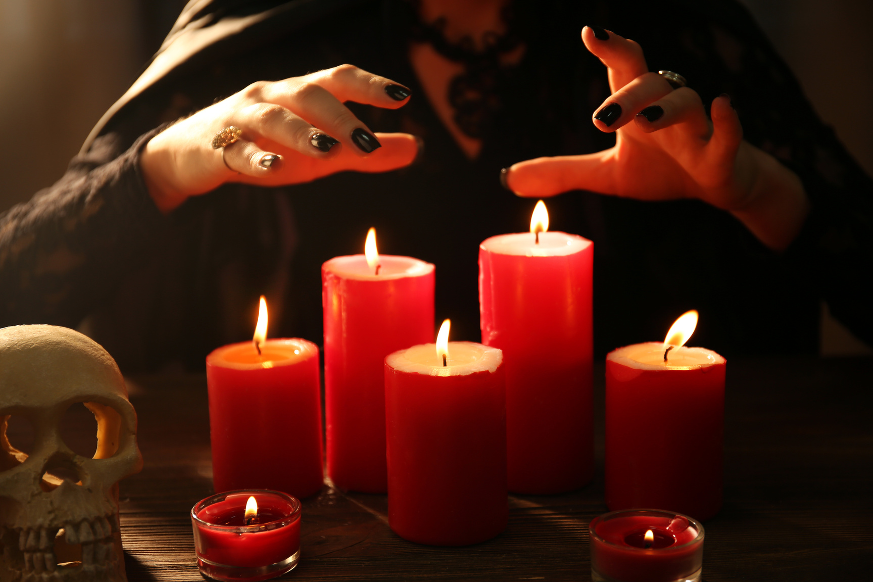 Woman's Hands Over Lit Candles